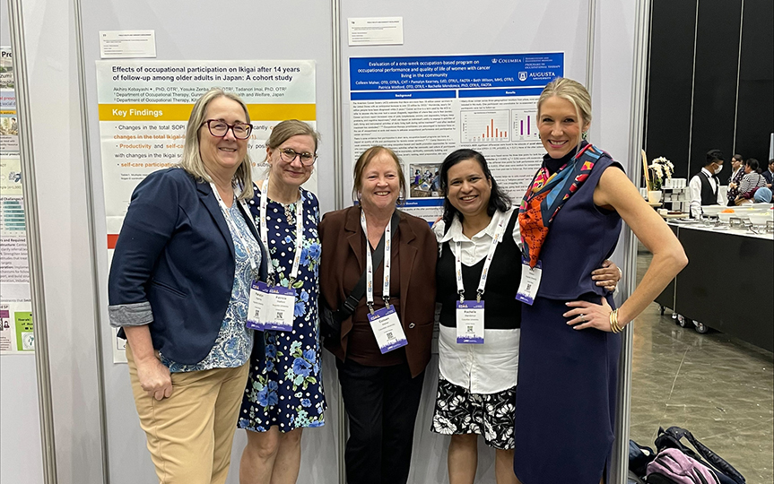 Five women standing in front of a poster
