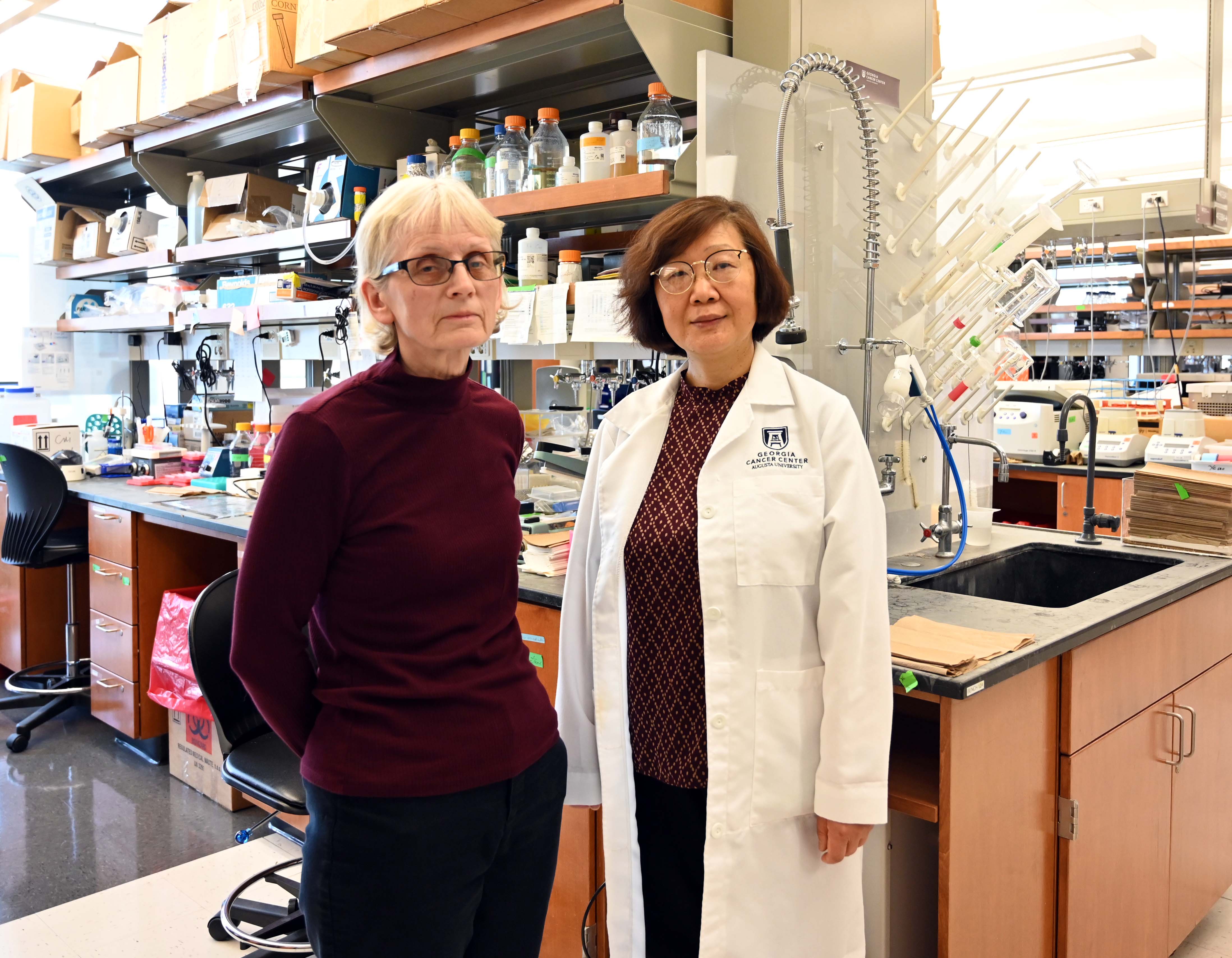 Two female researchers stand in a lab.