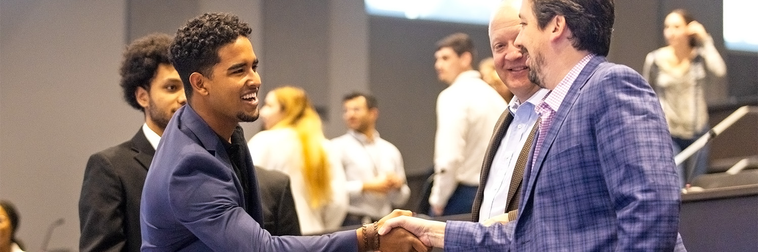 Allen Soto shaking the hand of a student.