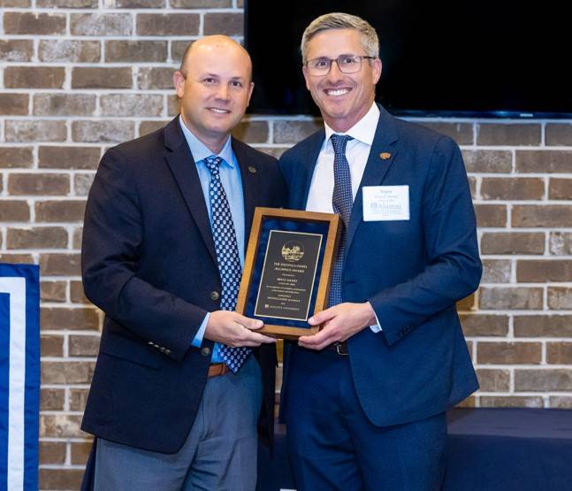 Bryce Massey accepting Distinguished Alumni award