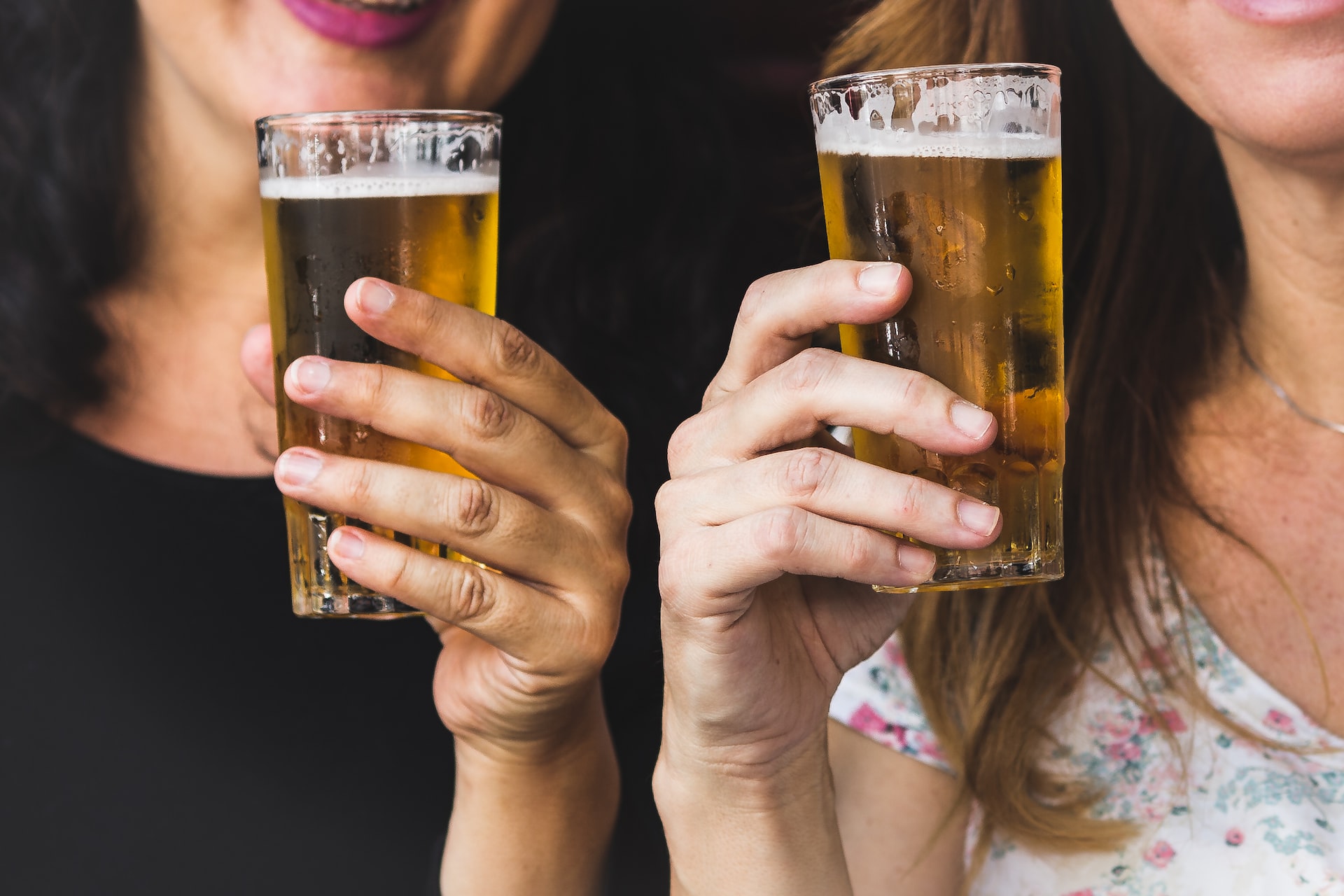 Woman holding glasses filled with beer