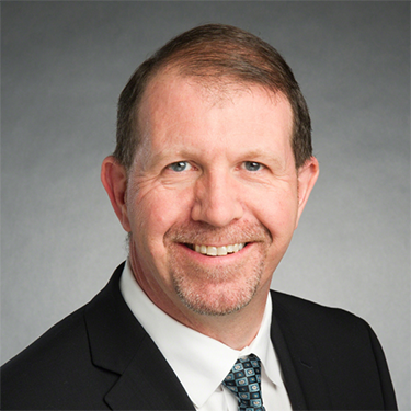 A man in a suit and tie smiling