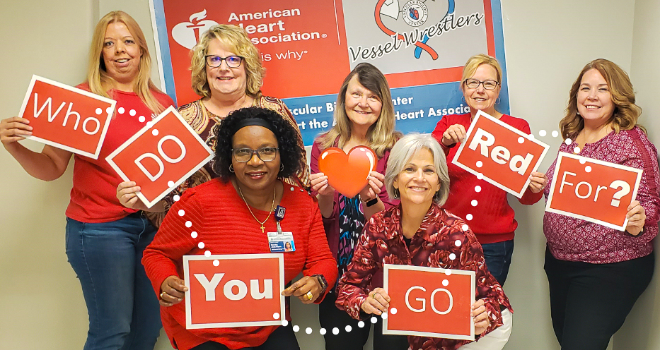 VBC Administrative Operations holding signs of words that say " Who do you go red for?"