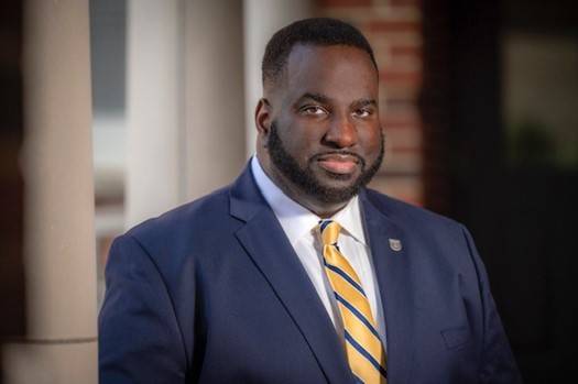 Stan Singleton Man wearing a suit and a yellow and blue striped tie
