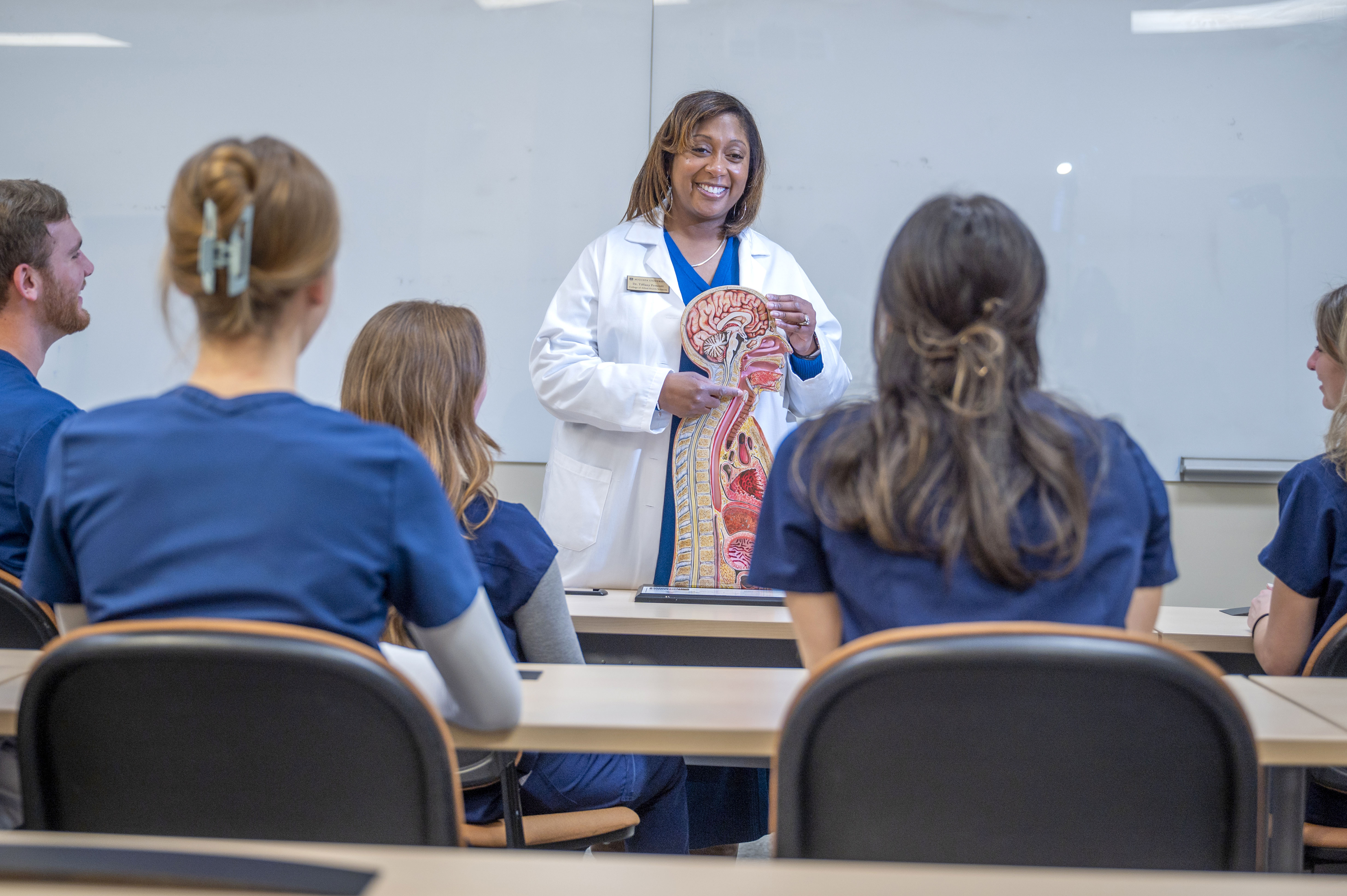 Female instructor teaching a Speech Language Pathology class to a group of students