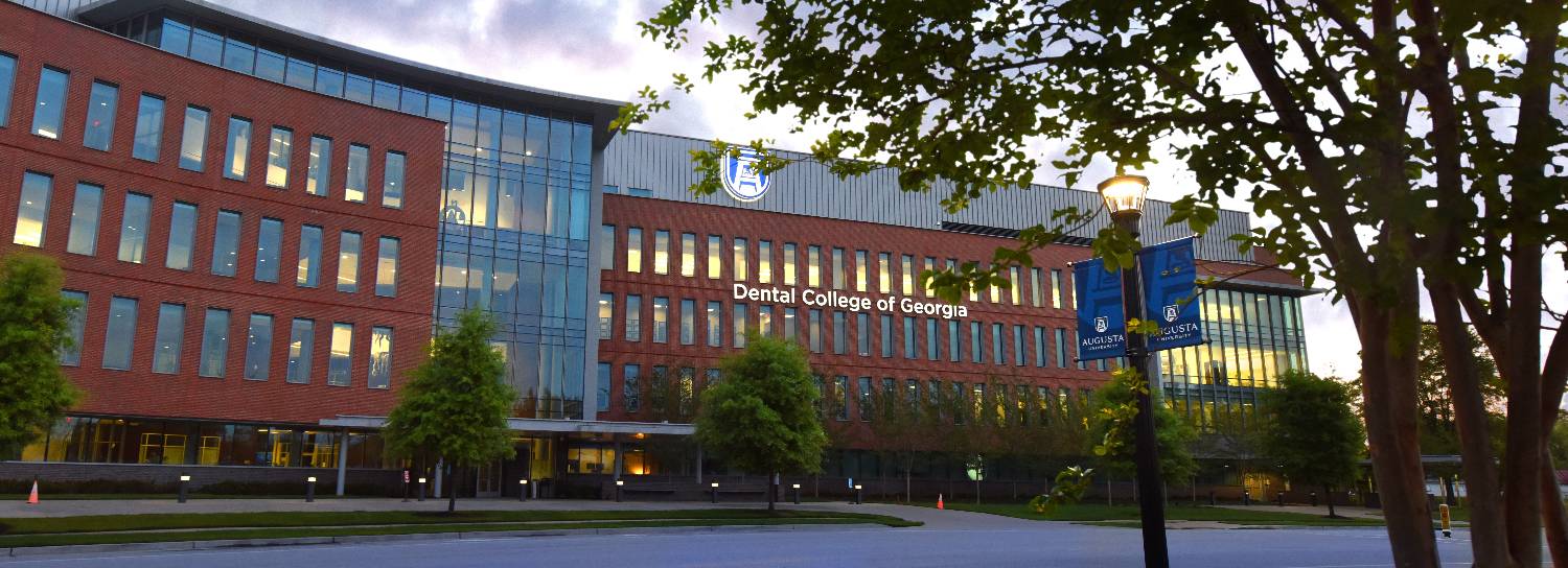 Exterior photo of the Dental College Building on the Health Sciences Campus at dusk