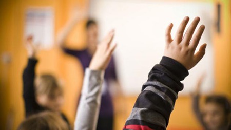 picture link of children raising hands in classroom