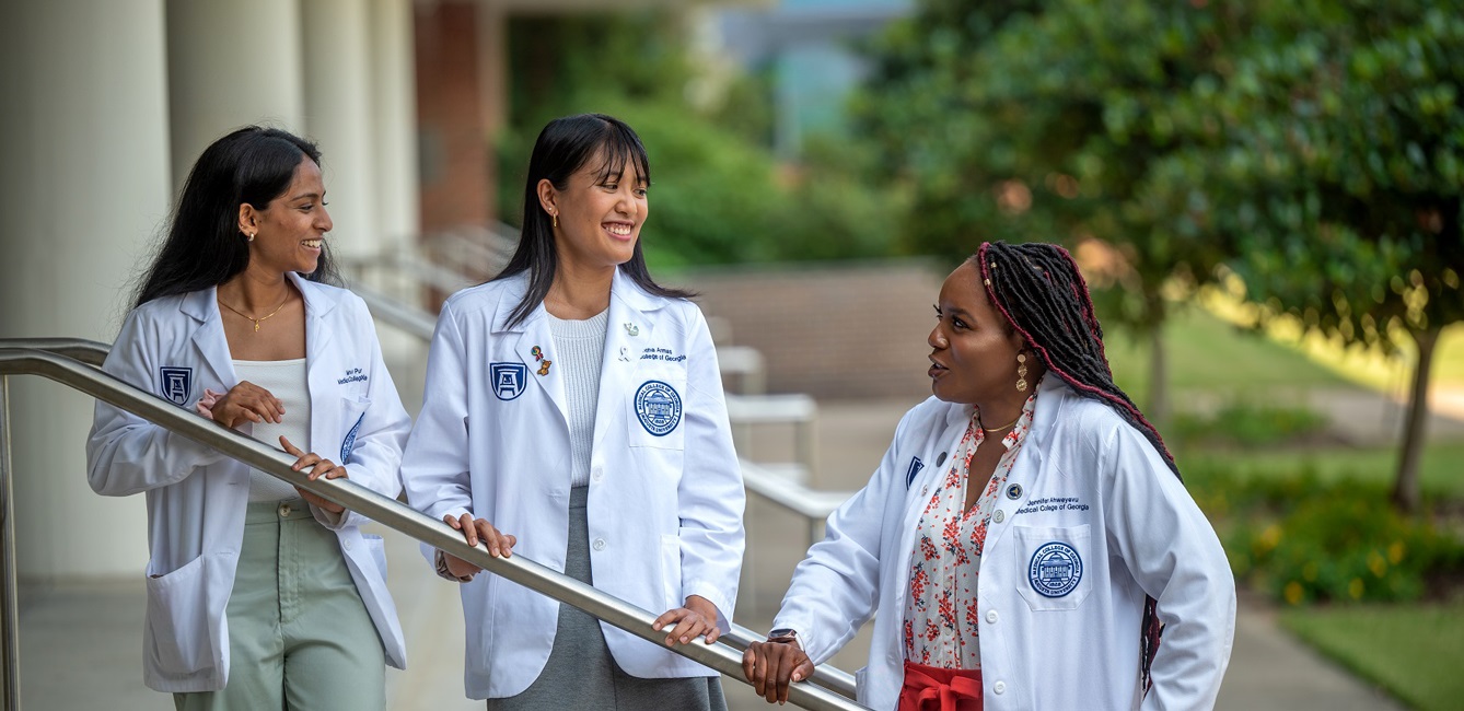 mcg students talk outside of a building