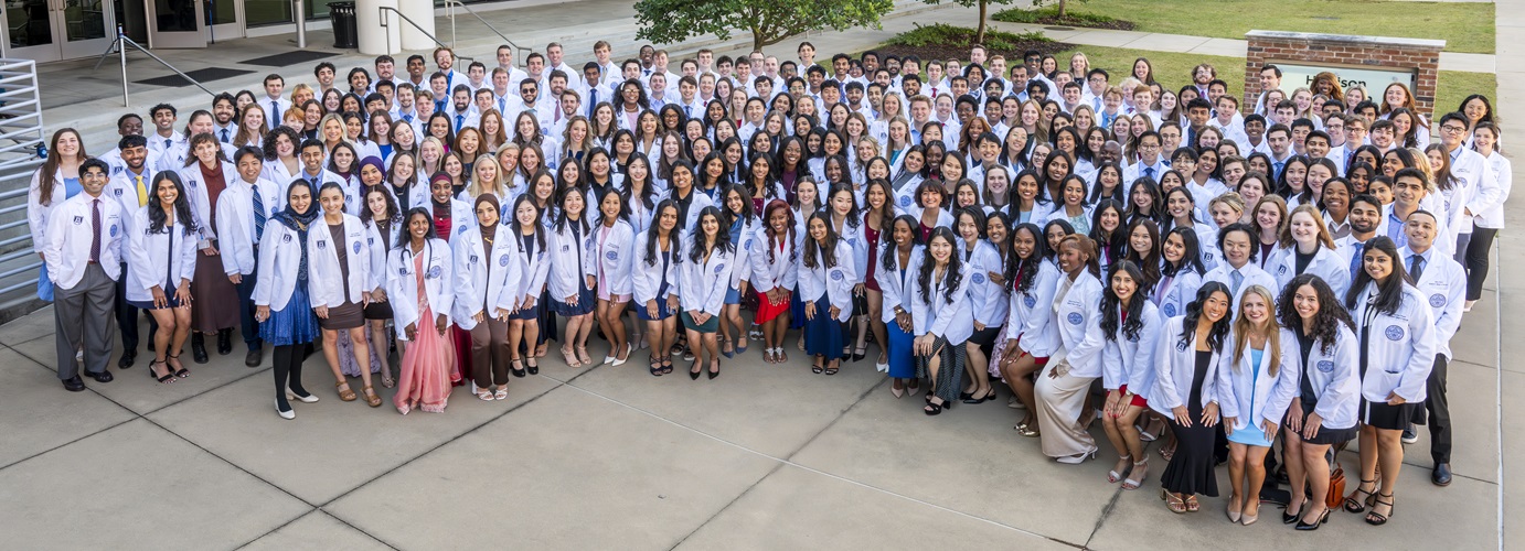 Group of people pose and smile for camera.