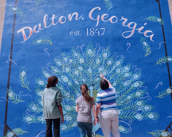 Students looking at a wall painting that says "Dalton, Georgia Est. 1847"