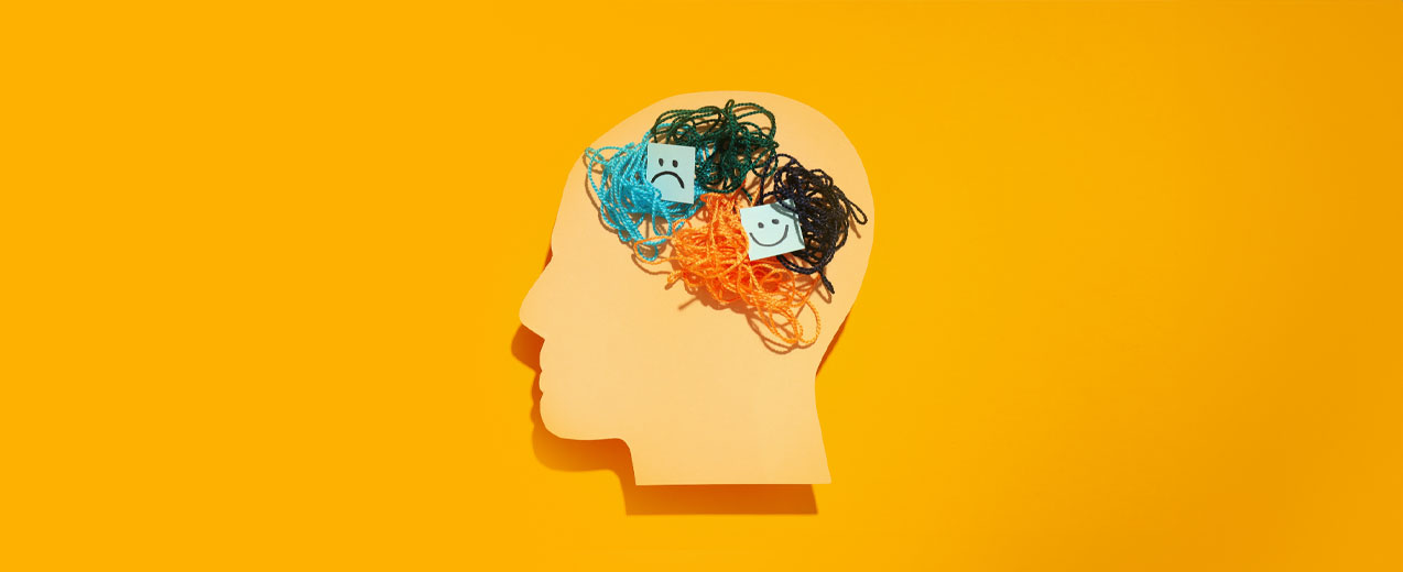 side profile of a paper cut out with a sad and happy face