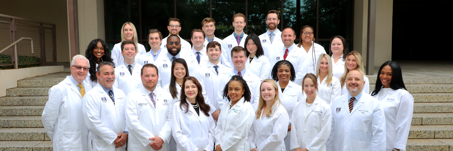 Photo of Urology faculty and residents in white coats posing in a group
