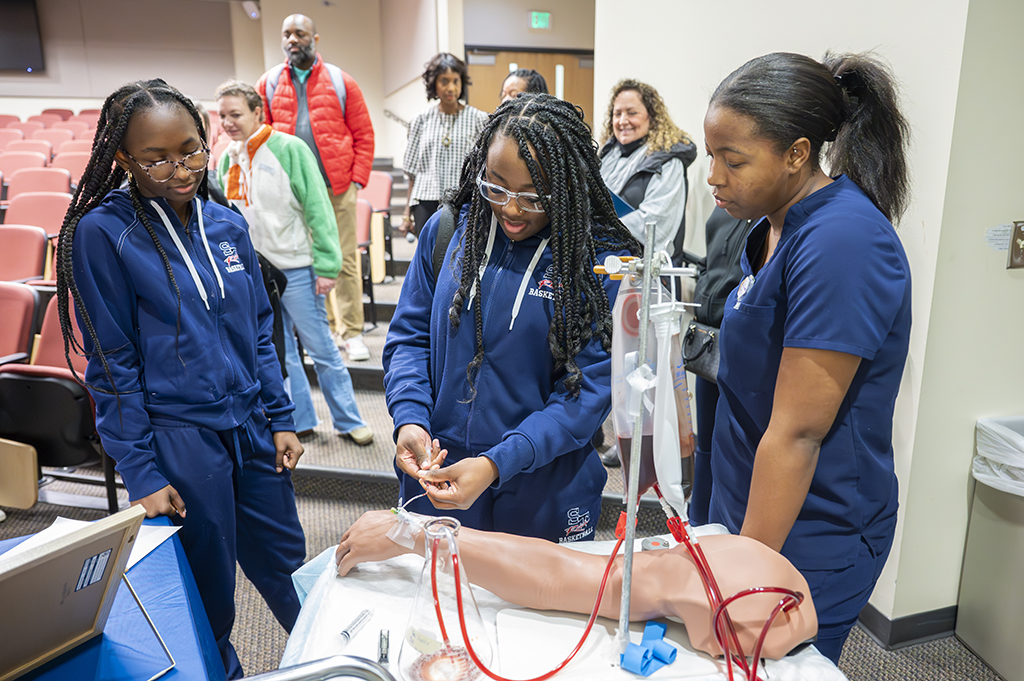 Augusta University student Kaili Williams (right), a senior studying nuclear medicine technology, demonstrates equipment to students from Strom Thurmond High School. [Michael Holahan/Augusta University]