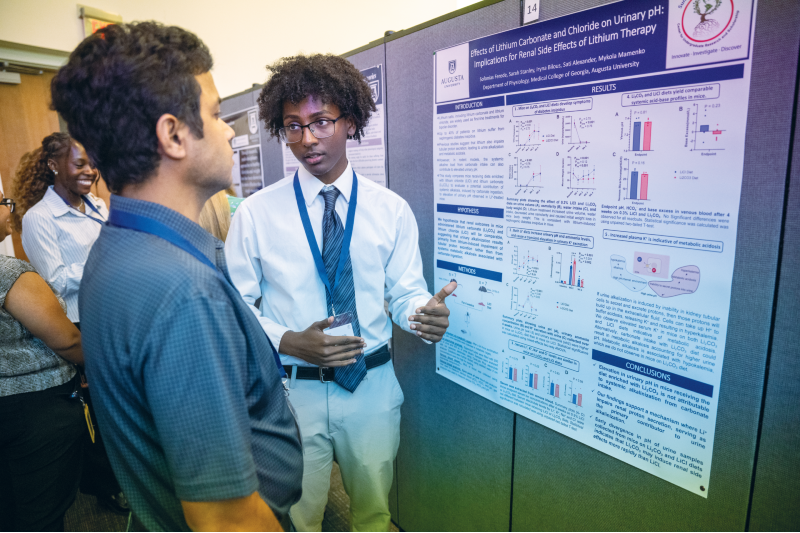 two men standing next to a poster