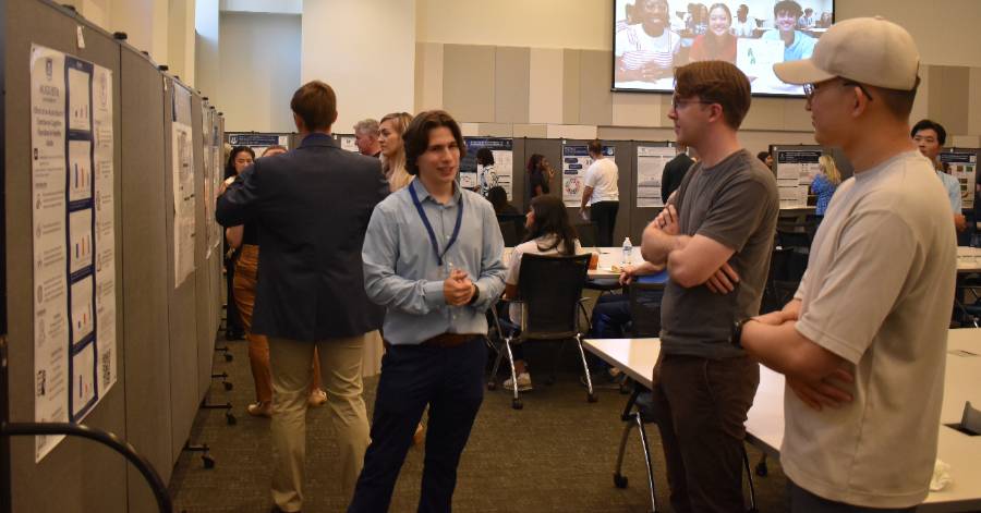 student speaking to two people