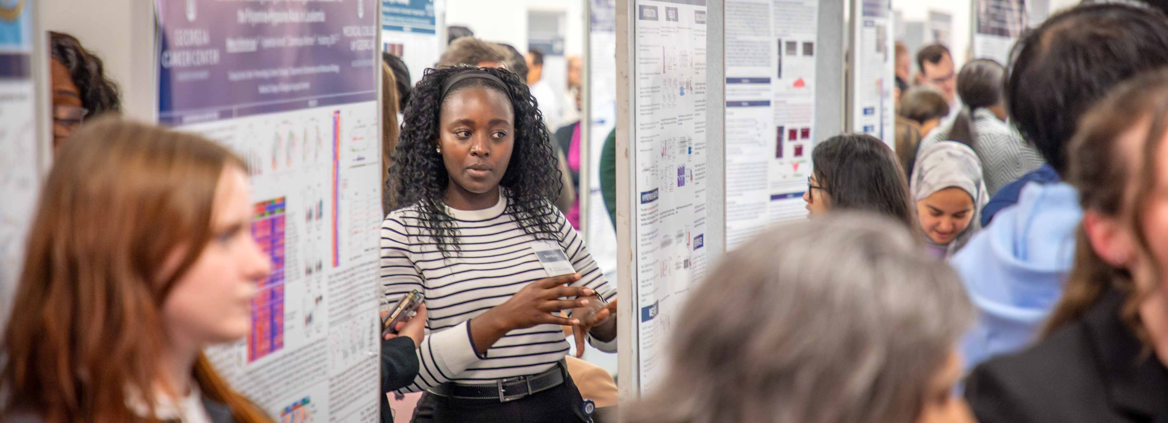 students and reviewers looking at research posters