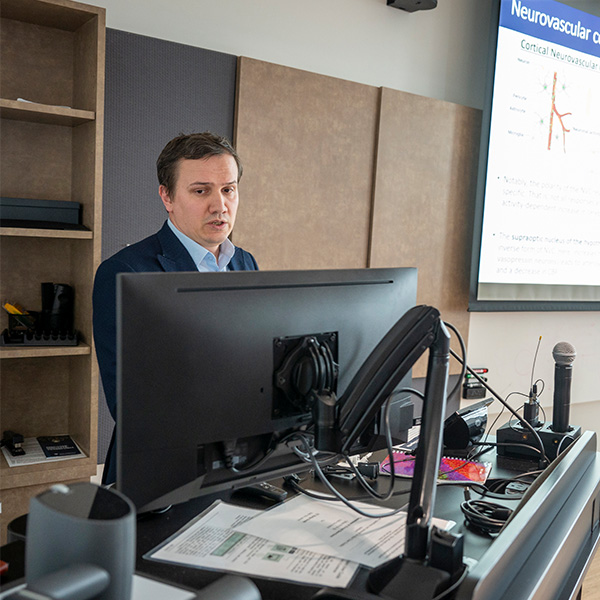 postdoctoral fellow delivering presentation in front of projected slide