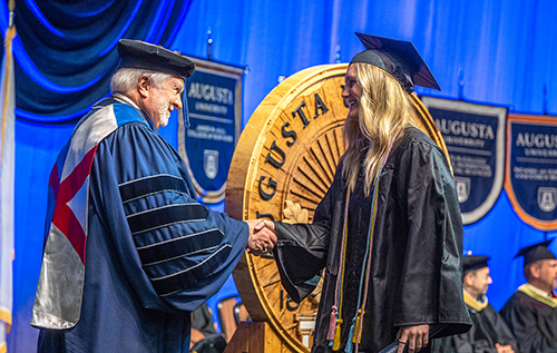 President Dr. Brooks Keel congratulates a graduate on stage