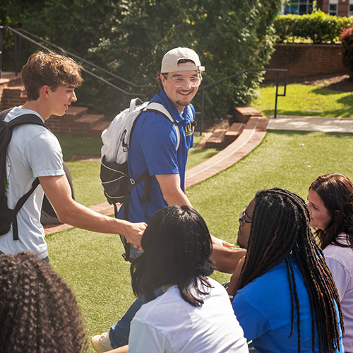 Group of fraternity and sorority members shaking hands