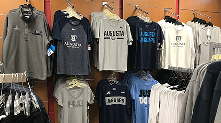 Augusta University branded shirts hanging on a wall