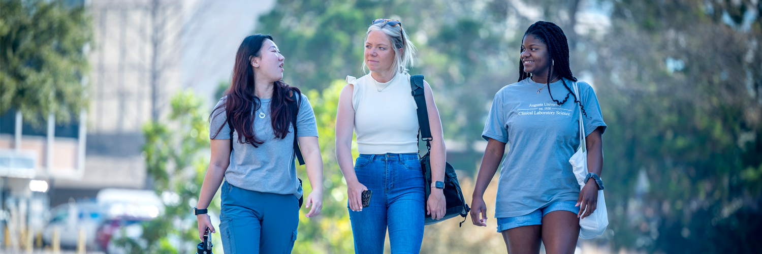 A photo of three female AU students walking together on campus