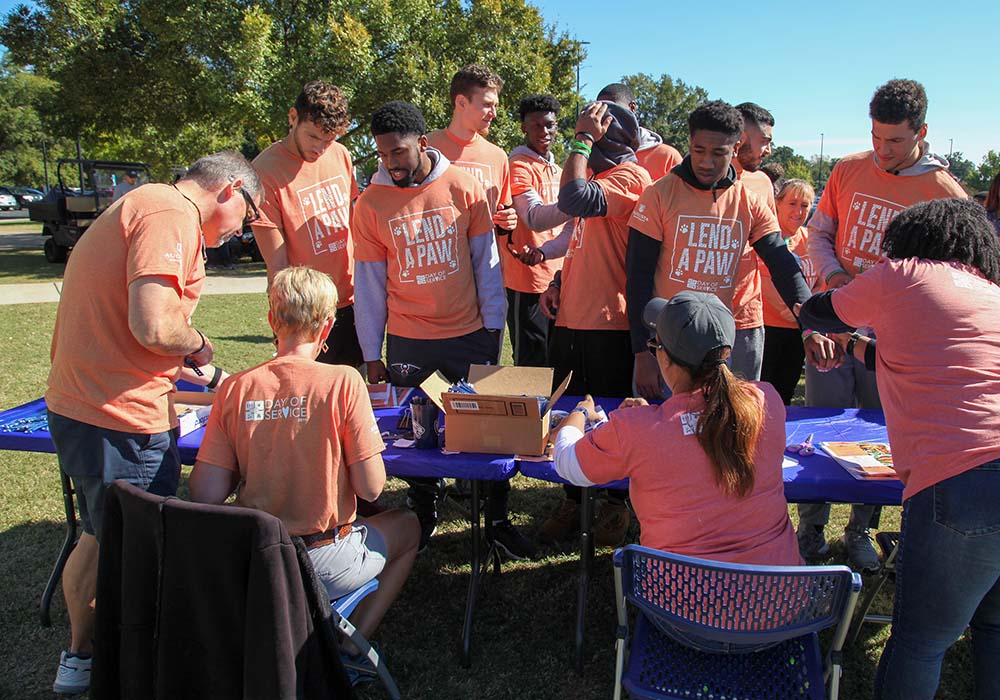 Group of students signing into service day at table