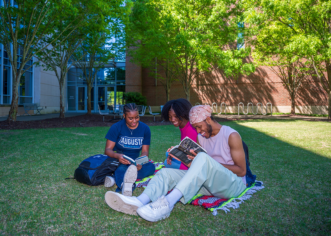 students relaxing on campus lawn