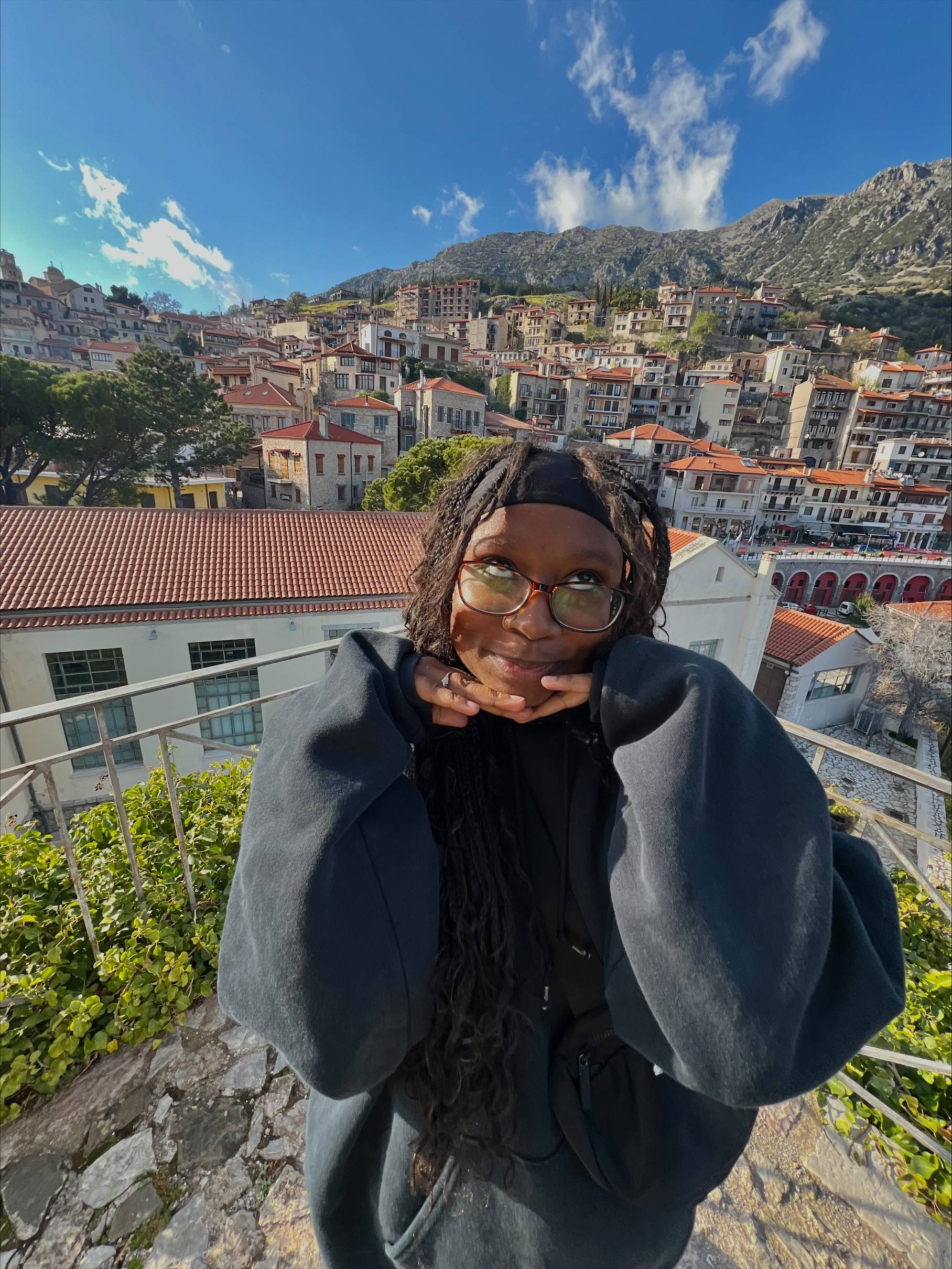 woman in glasses makes a face in front of mountain