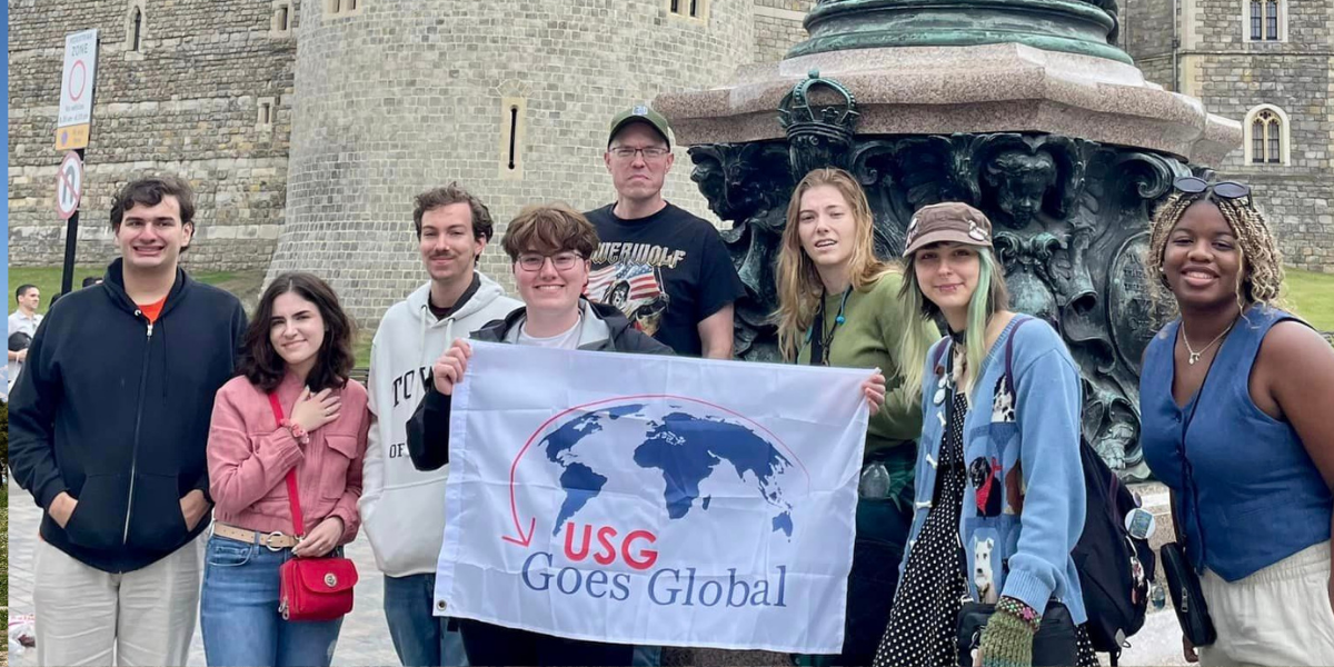 students posing with flag